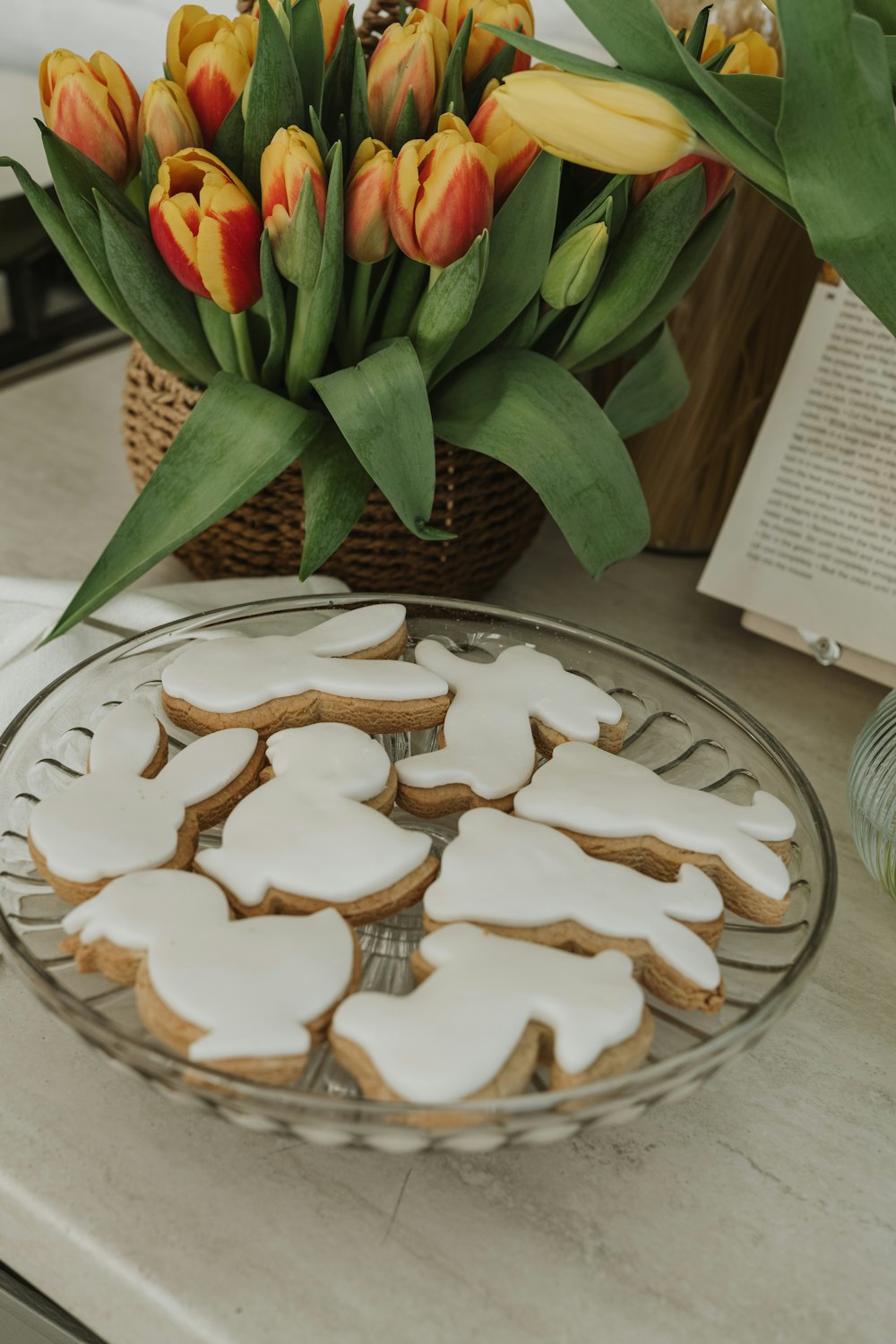 a plate of cookies and flowers on a table