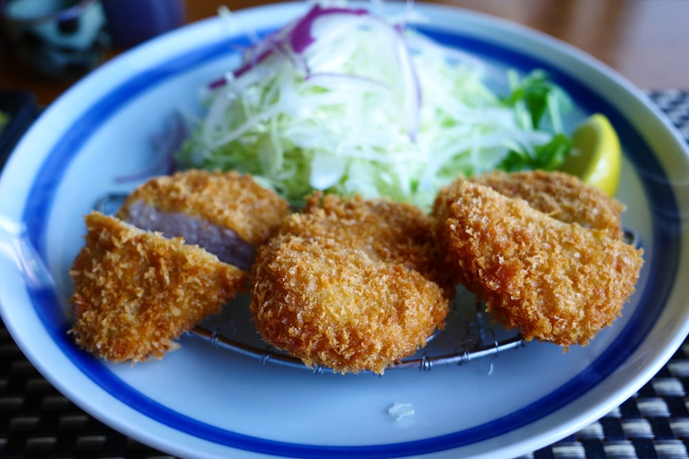 a blue and white plate topped with fried food