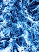 Graphene sheets layered with metallic blue hues reflecting light.