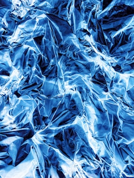 Graphene sheets layered with metallic blue hues reflecting light.