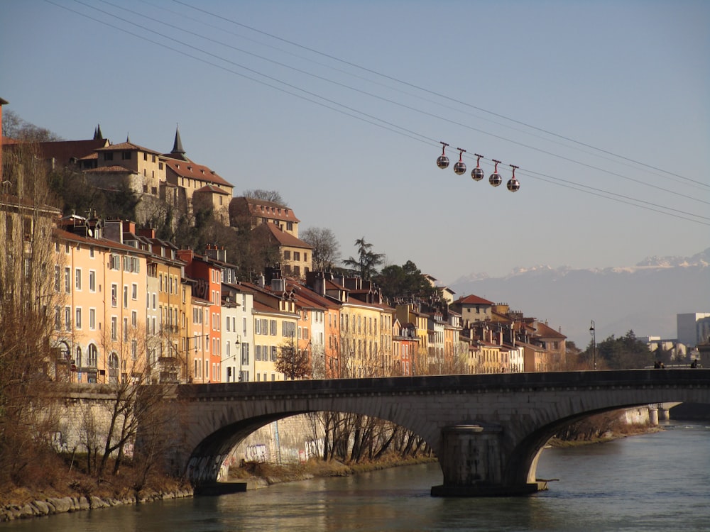 um teleférico passando por uma ponte sobre um rio