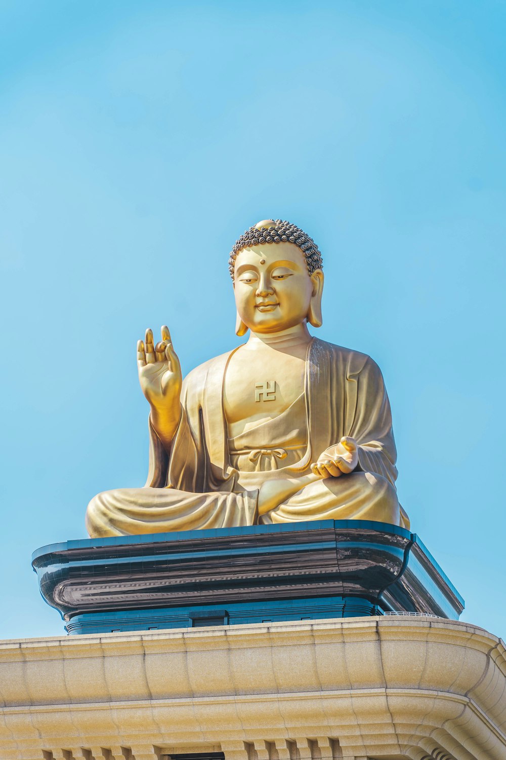 a golden buddha statue sitting on top of a building