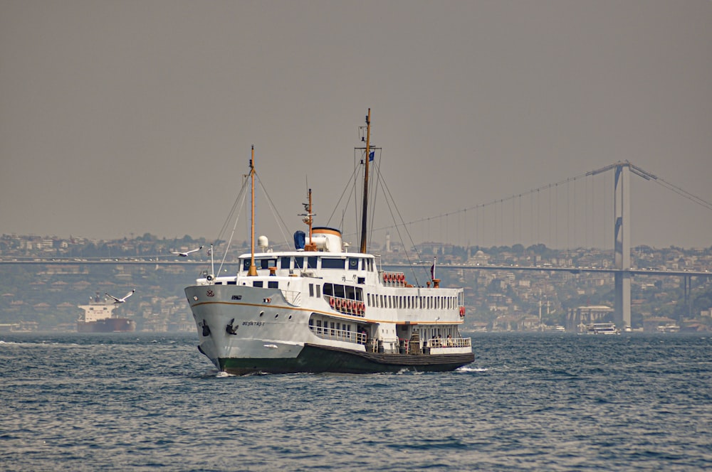 a large boat in the water near a bridge