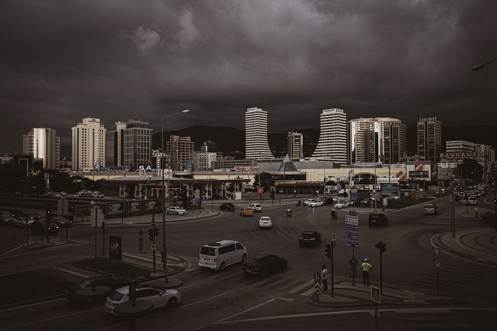 a city street filled with lots of traffic under a cloudy sky