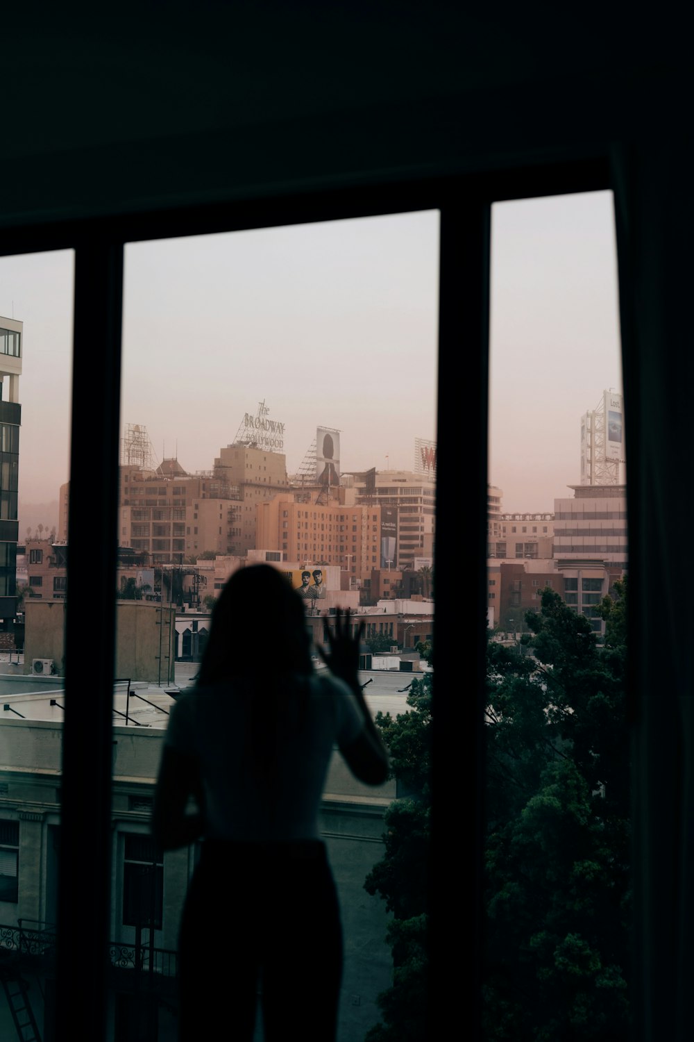 a woman looking out a window at a city