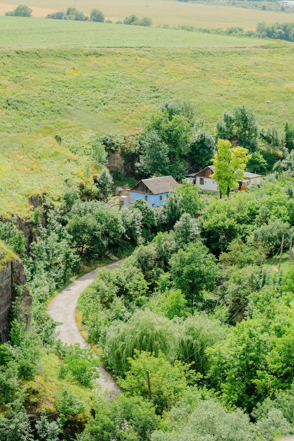 an aerial view of a house in the middle of a lush green field