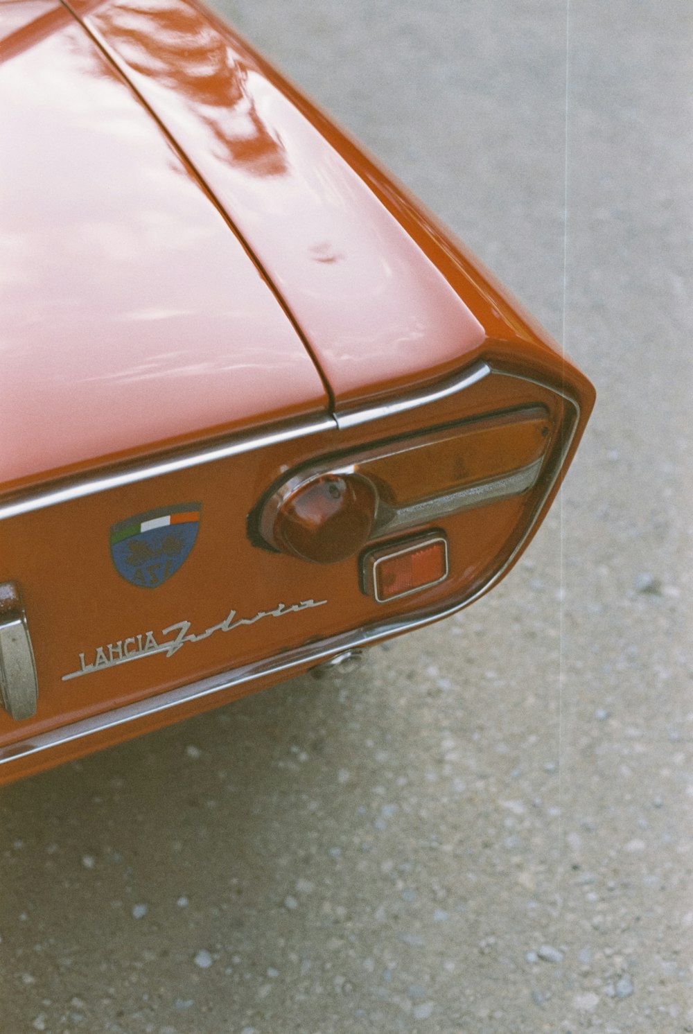 a close up of a red car with a badge on it