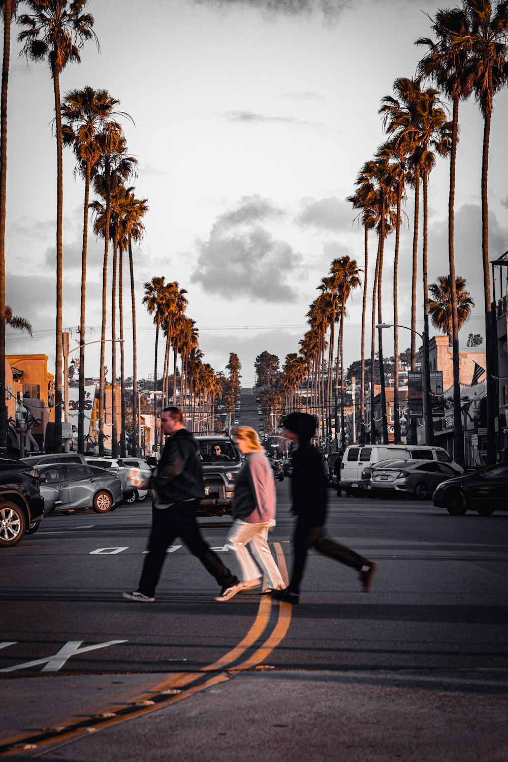 a group of people walking across a street