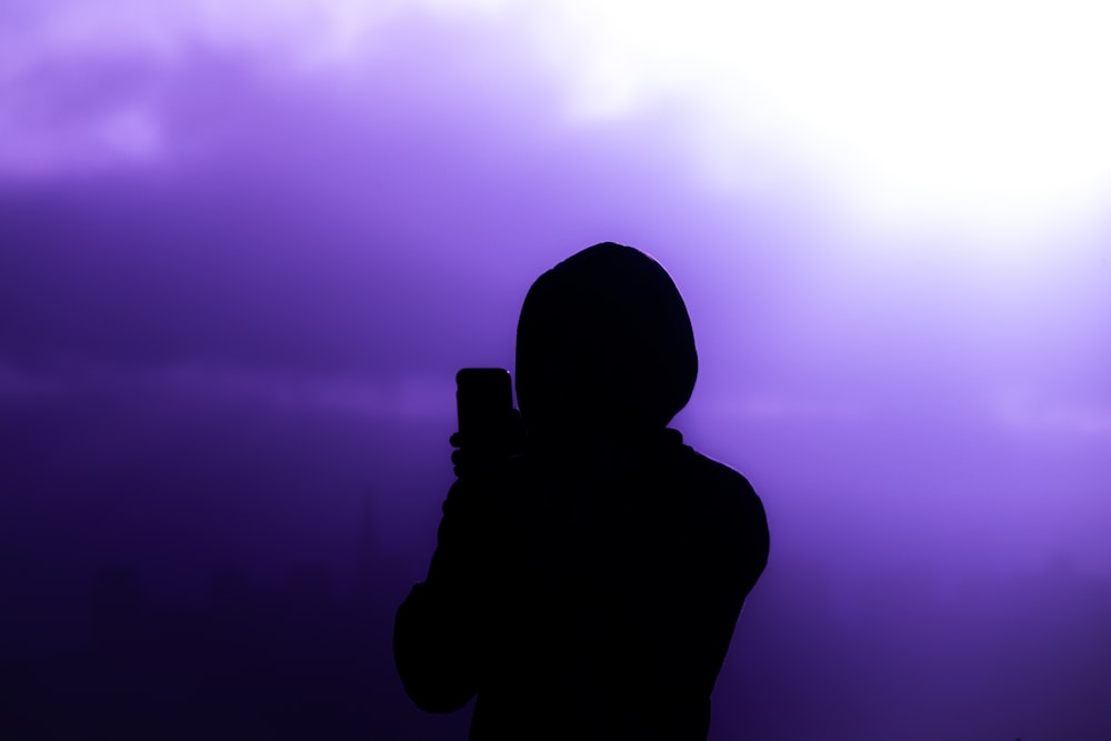 a person in a hoodie holding a cell phone