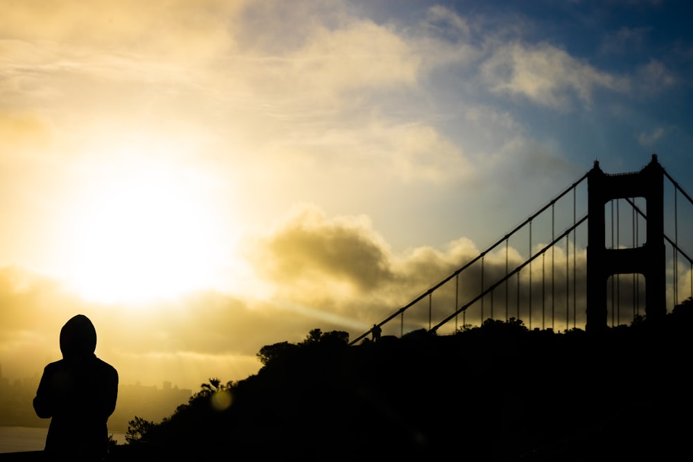 a person standing in front of the golden gate bridge