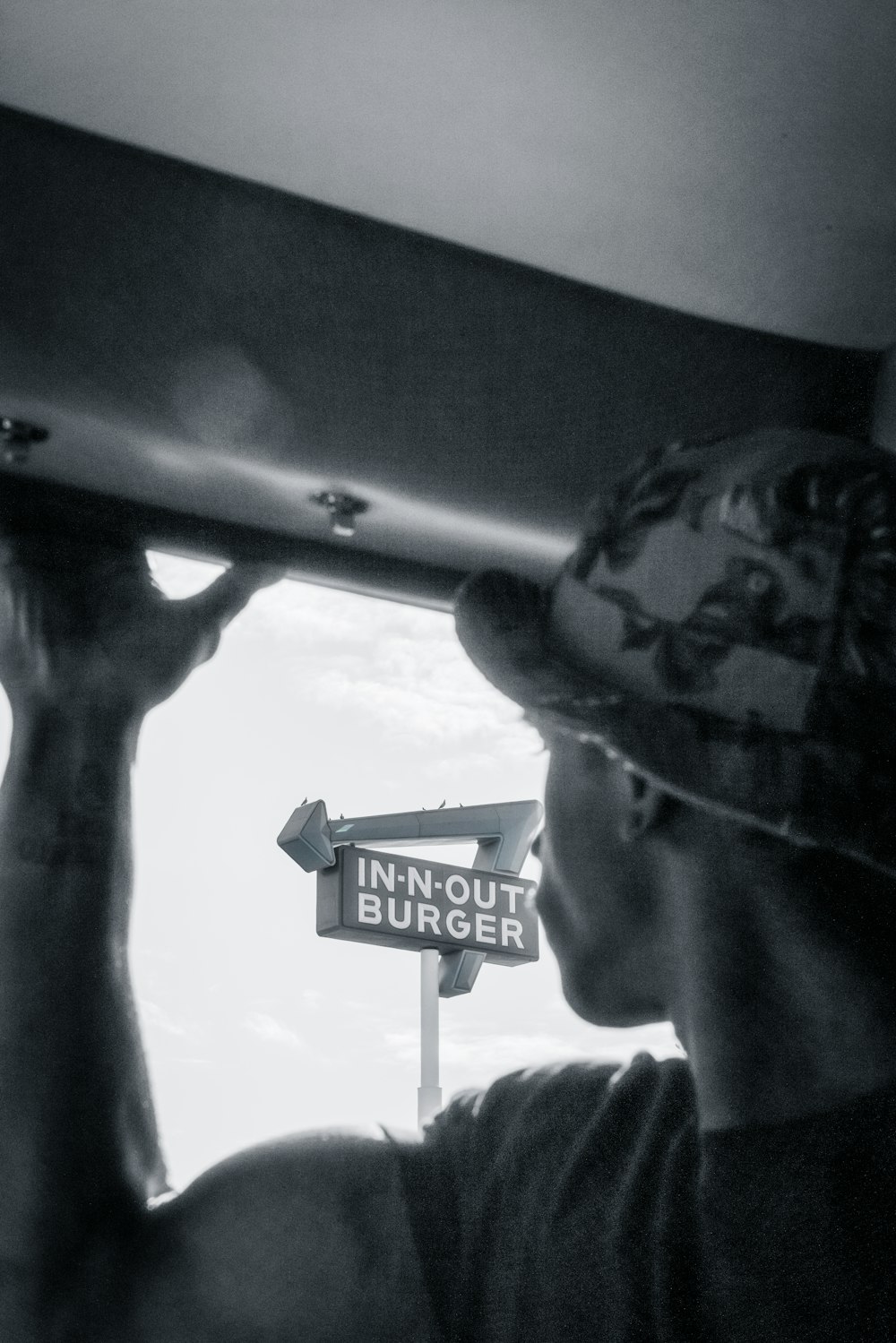 a man holding a sign that says in out burger