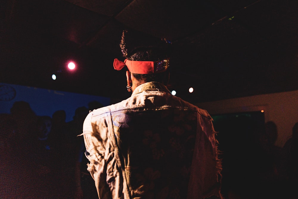 a man in a cowboy hat standing in a dark room
