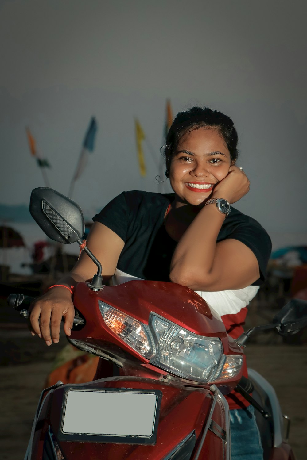 a woman is sitting on a red motorcycle