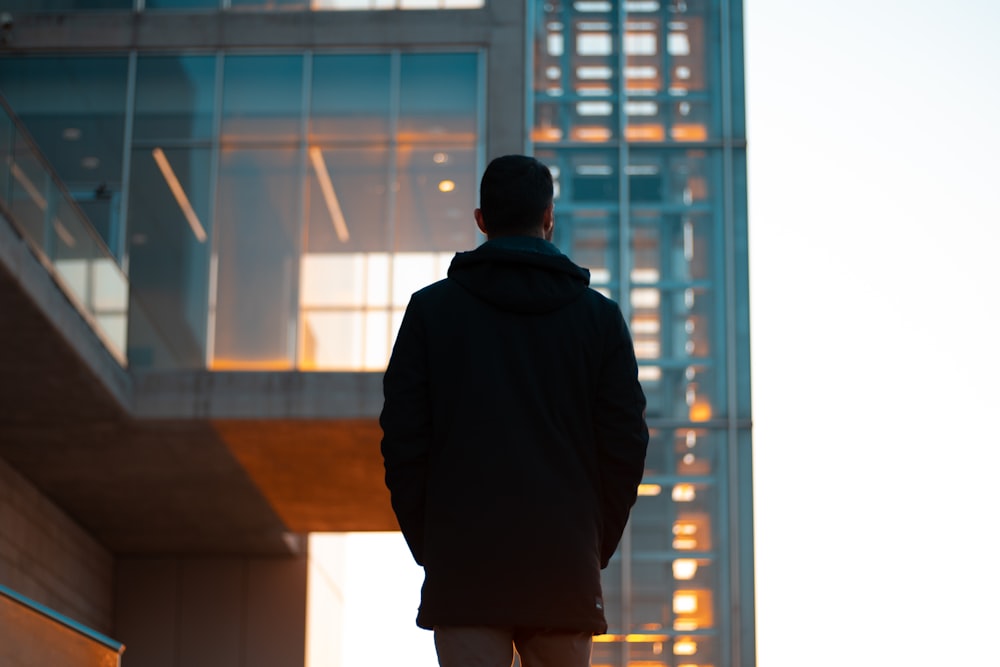 a man standing in front of a tall building