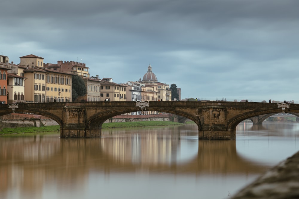 a bridge over a body of water with buildings in the background