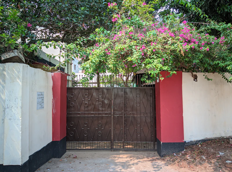 Portão marrom em muro vermelho e branco