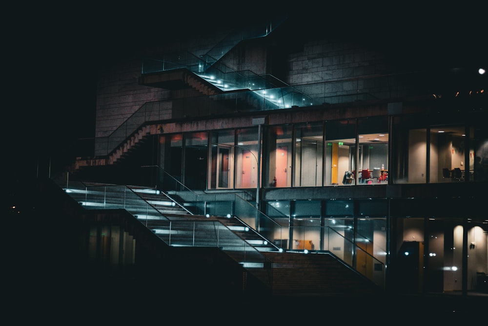 a building lit up at night with stairs leading up to it