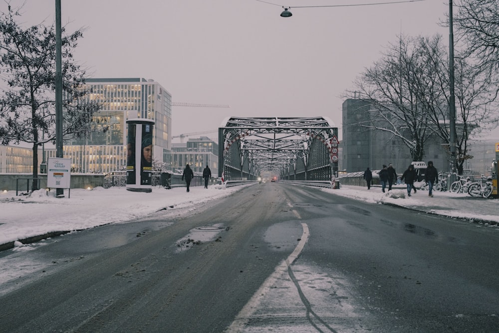 a snowy street with people walking on it