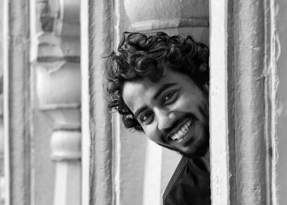 a black and white photo of a smiling man