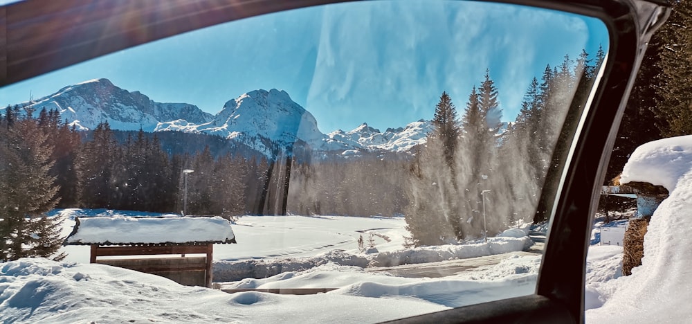 a view of a snowy mountain from a car window