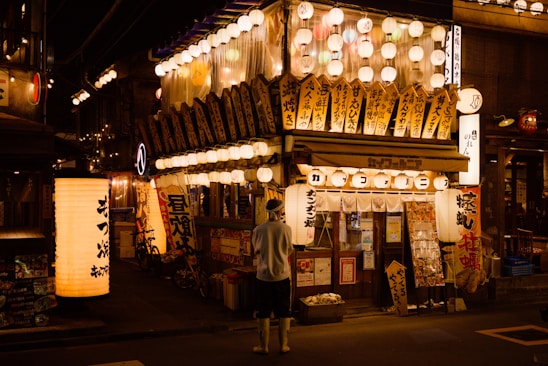 A vibrant photo of a bustling Japanese street market with colorful lanterns and smiling travelers.