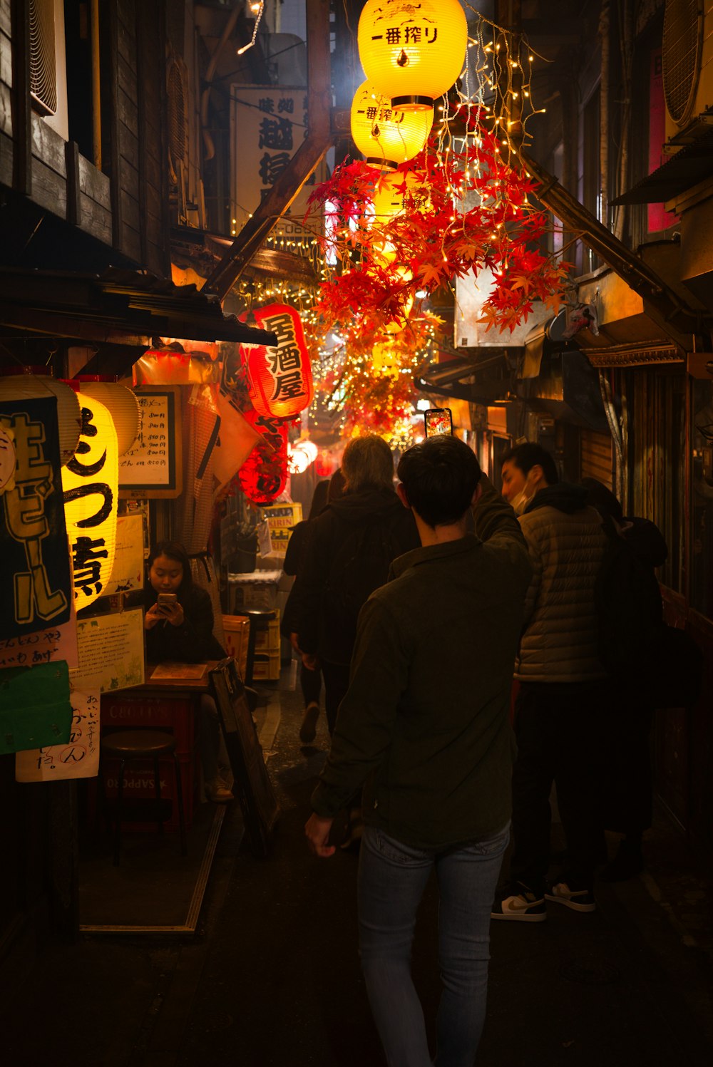 a group of people walking down a street at night