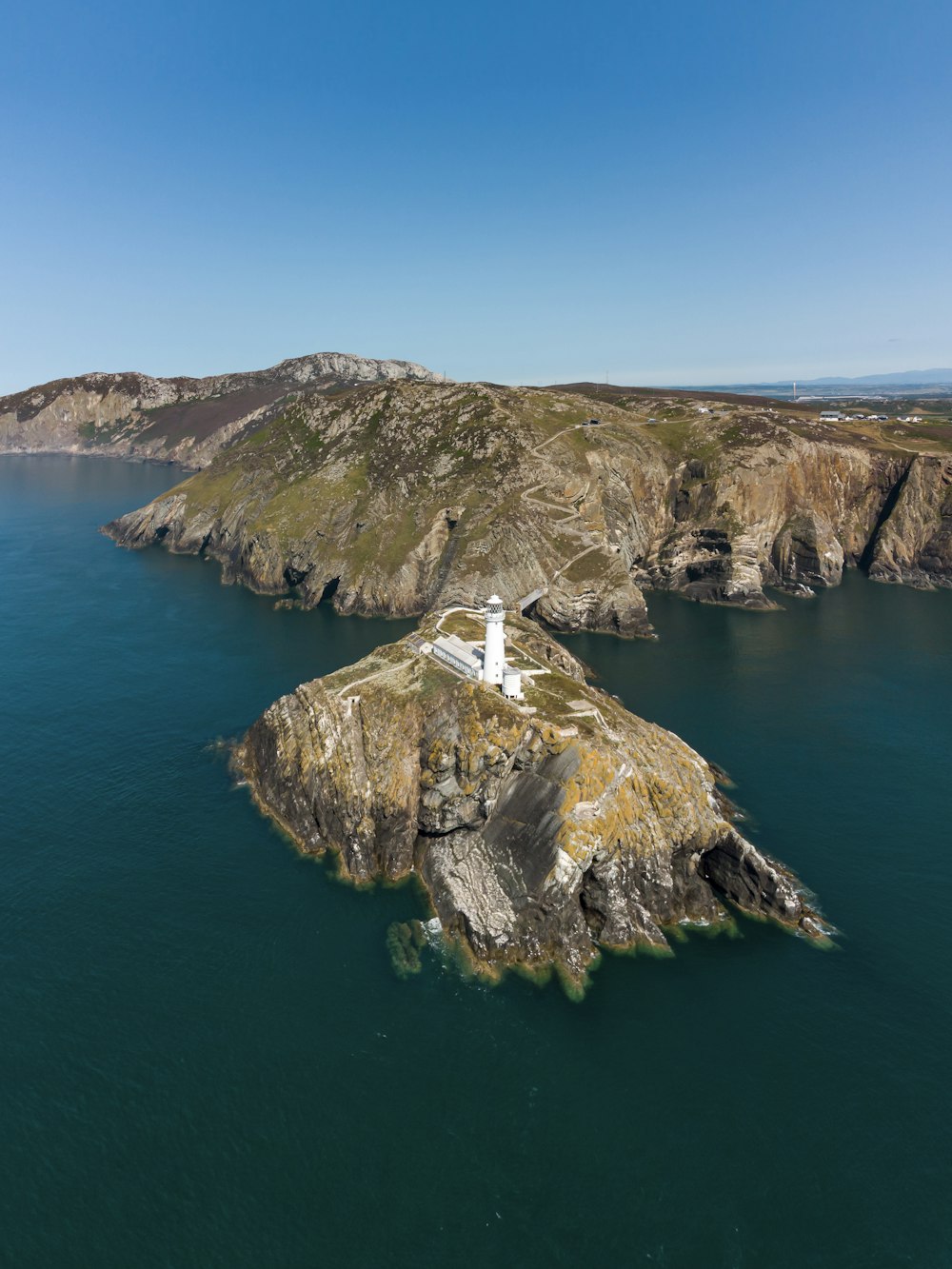 a lighthouse on a small island in the middle of the ocean