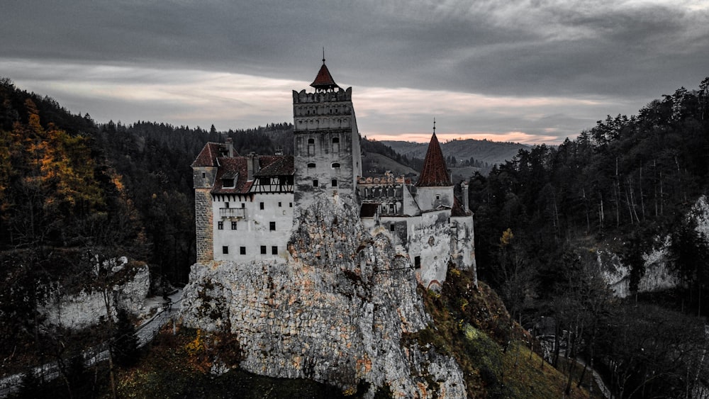 a castle on top of a mountain with a cloudy sky