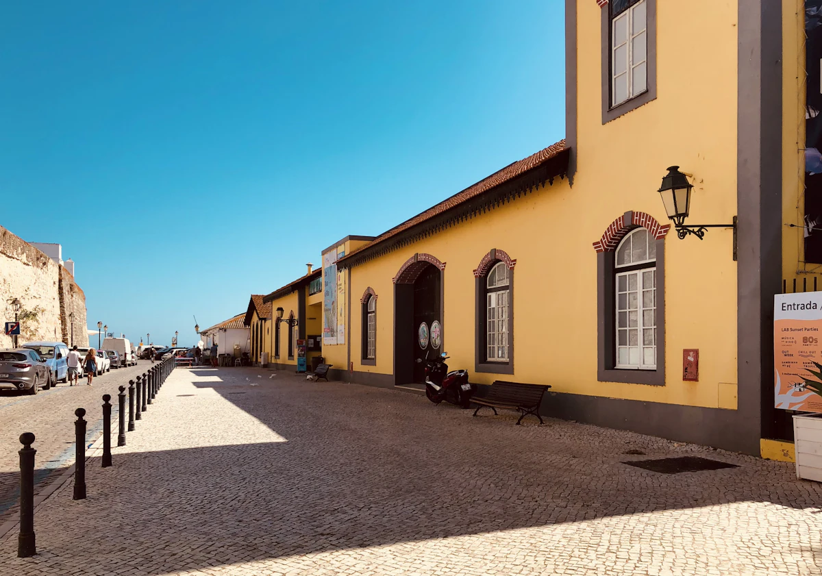 Cobblestone street lined with yellow houses