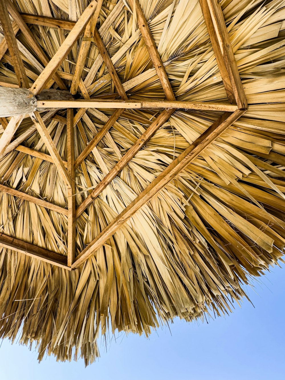 a straw umbrella with a blue sky in the background