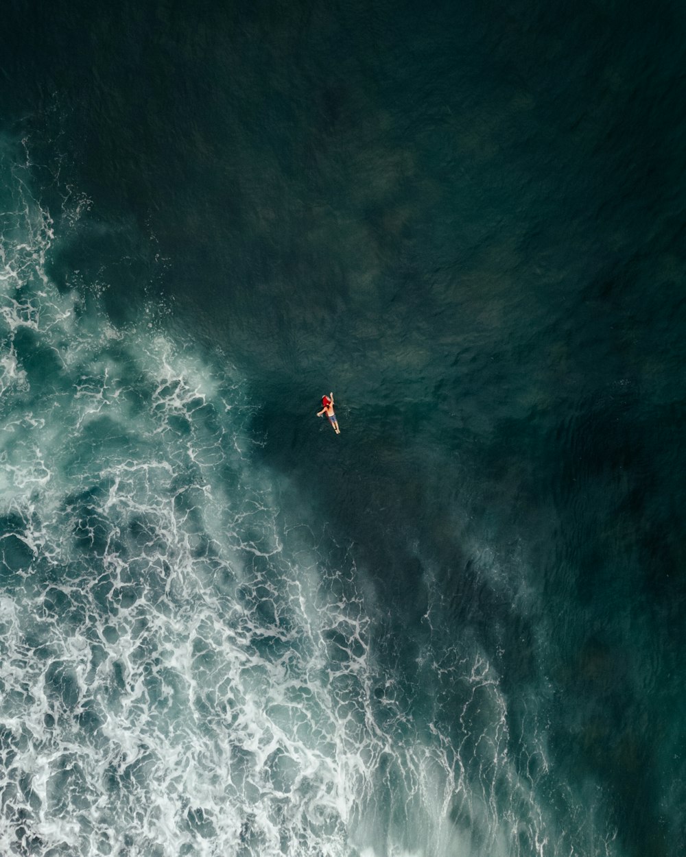 a man riding a surfboard on top of a wave in the ocean