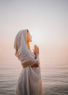 a woman in a white dress standing in the water
