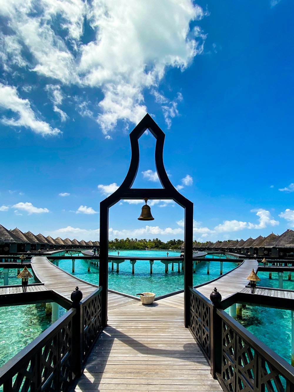 a wooden dock with a bell on top of it