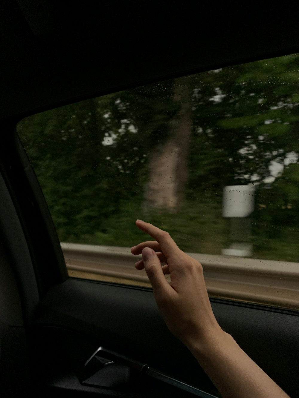 a person holding their hand out of a car window