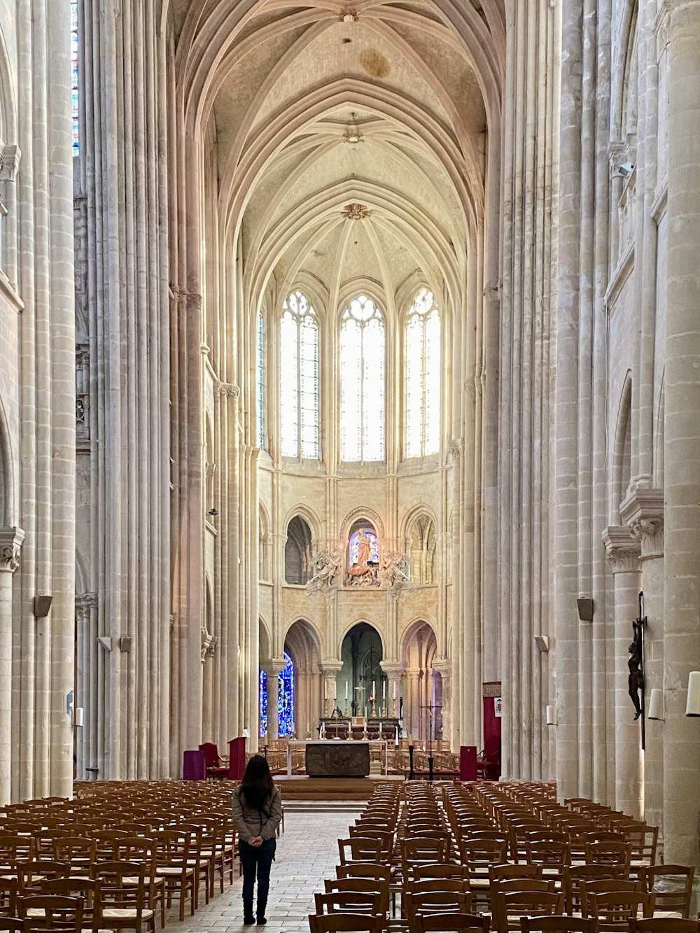 a woman is standing in a large cathedral