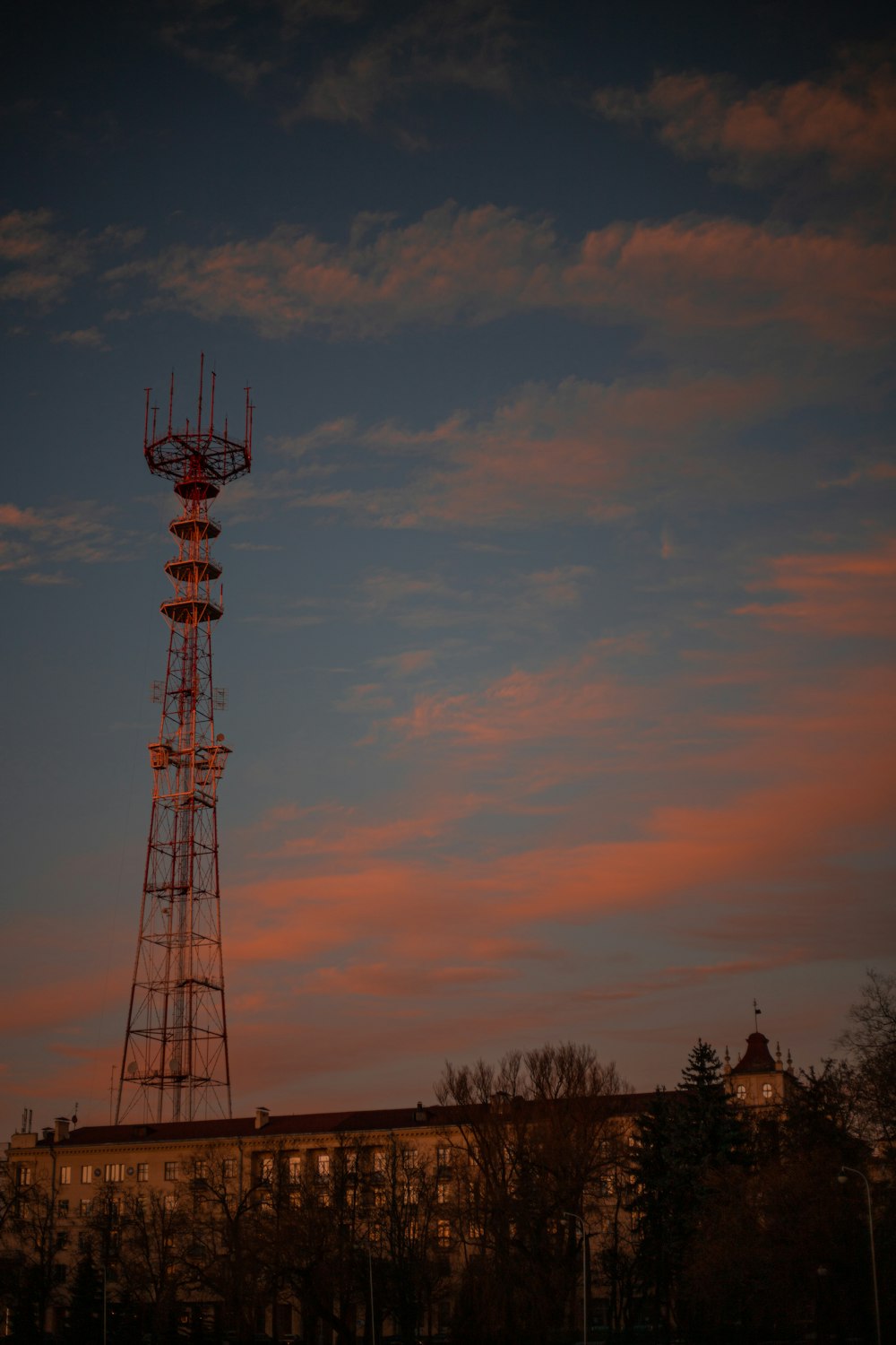 a tall tower sitting next to a building under a cloudy sky