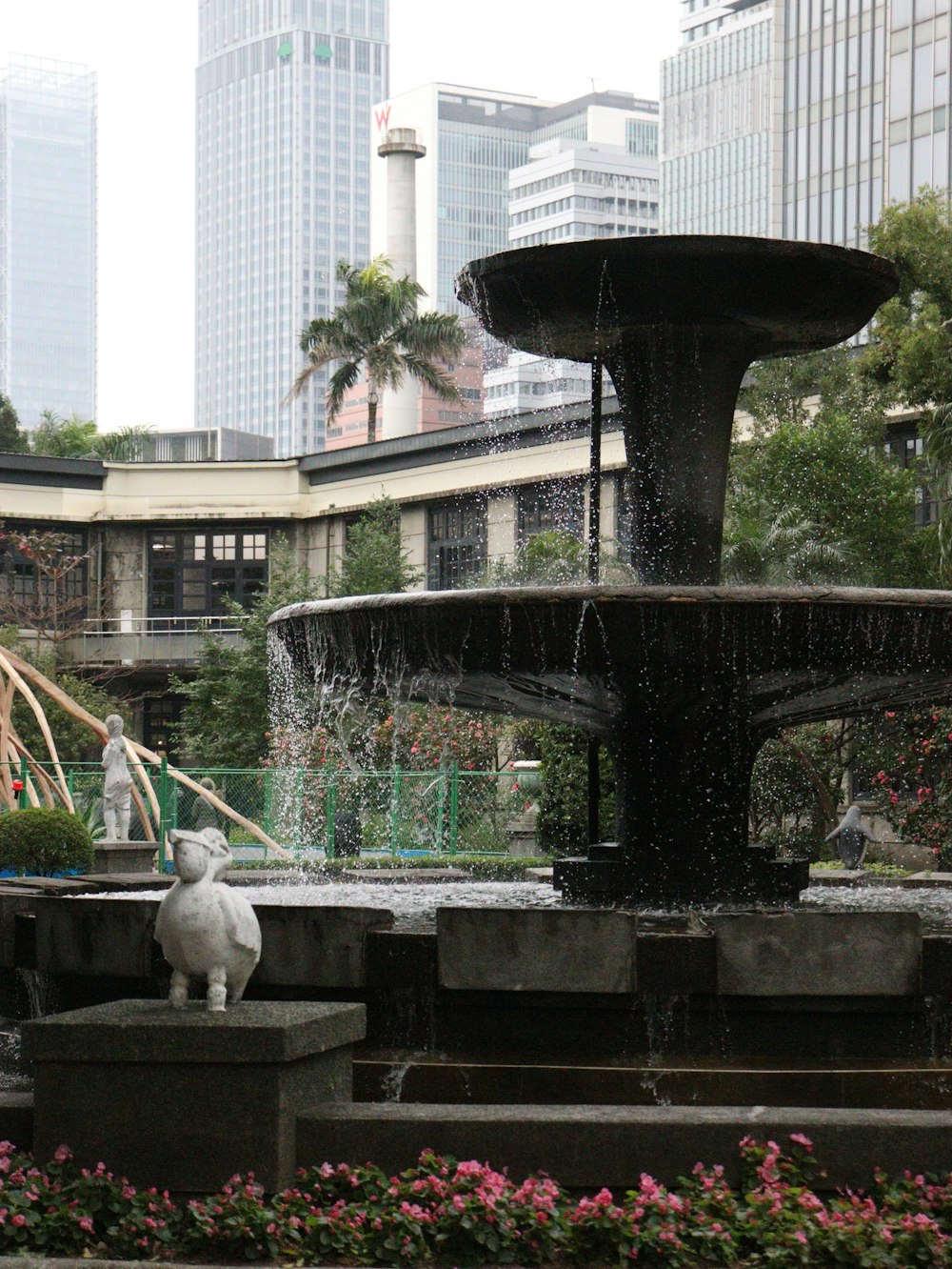 Una fuente en un parque de la ciudad con gente caminando alrededor