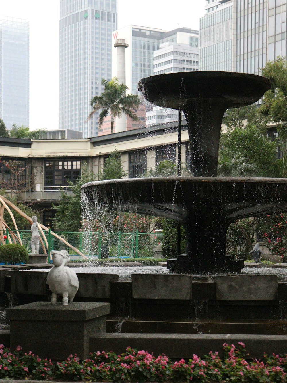 a fountain in a city park with people walking around