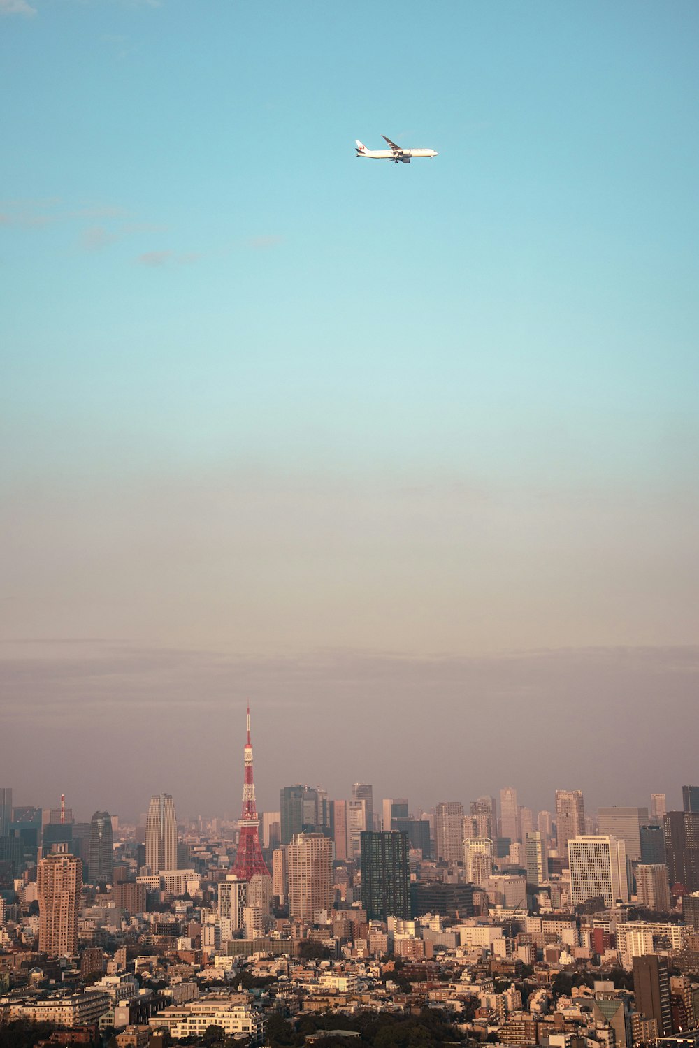 an airplane flying over a city with tall buildings