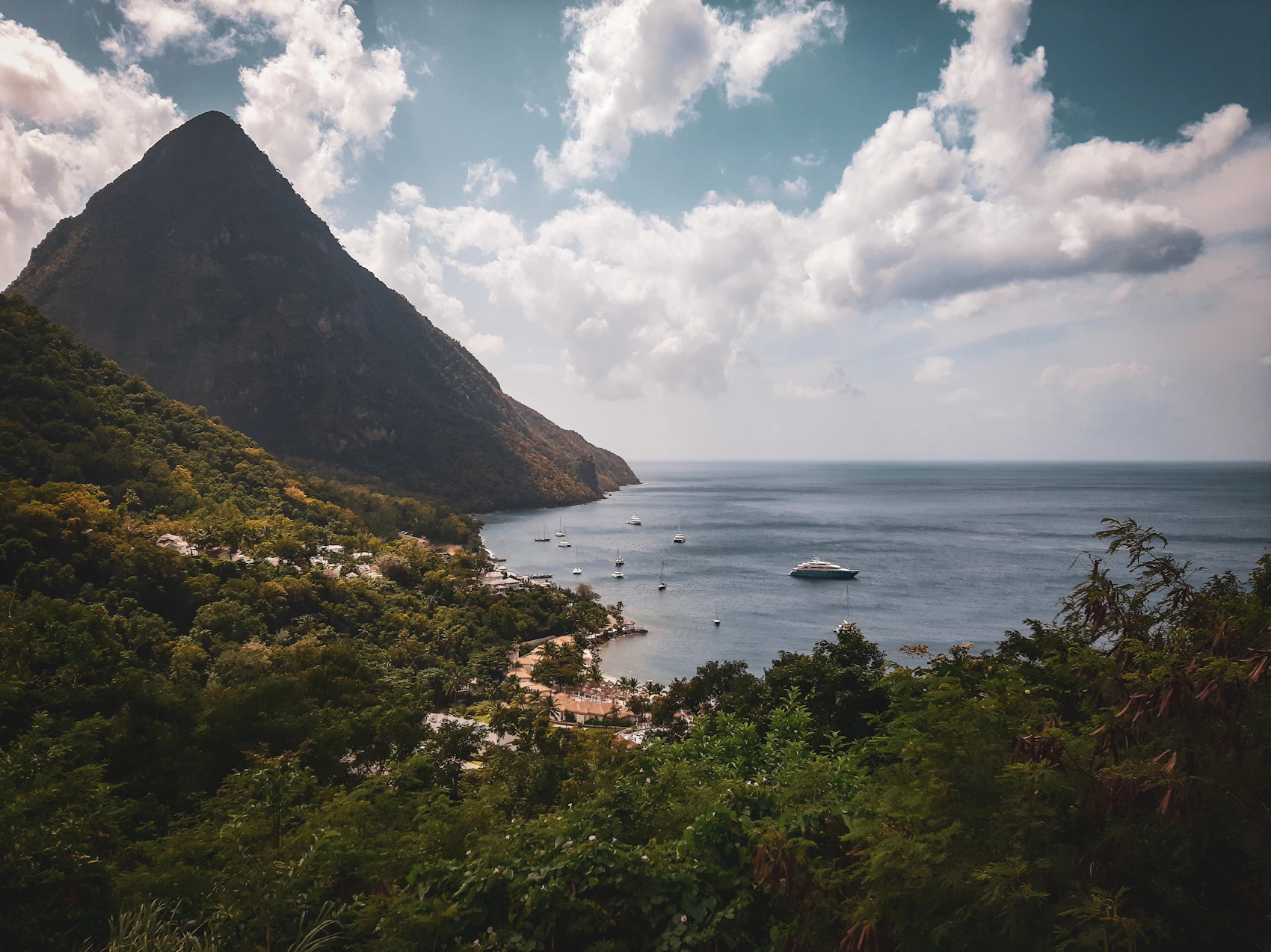 Petit Piton rising above a sheltered Saint Lucia bay with boats at anchor