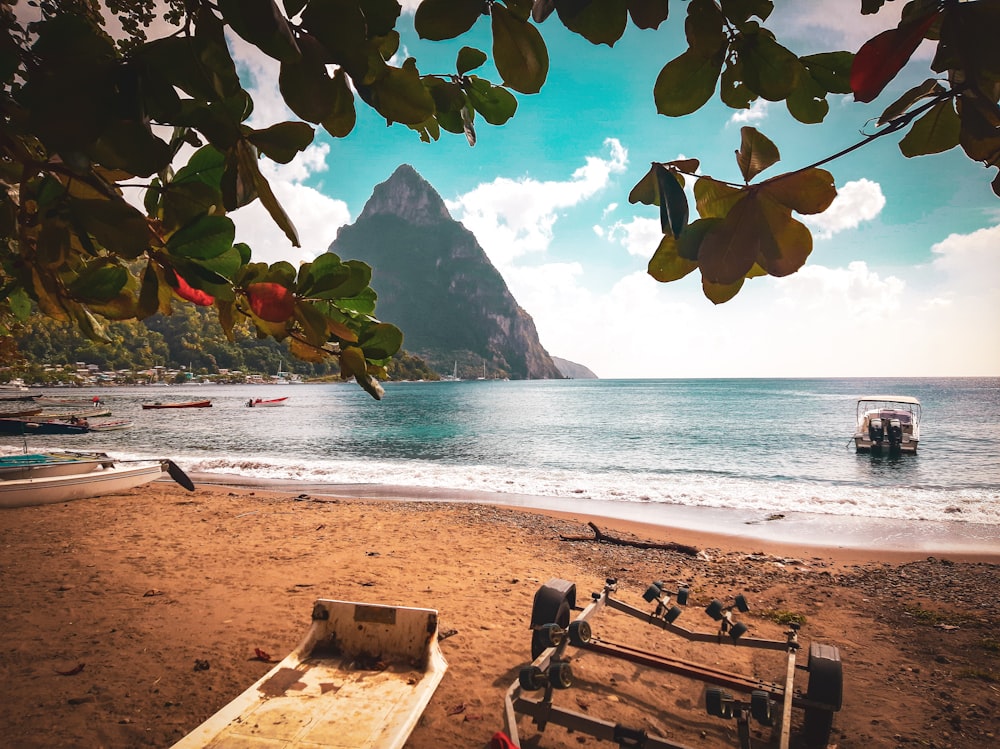 a boat sitting on top of a beach next to the ocean