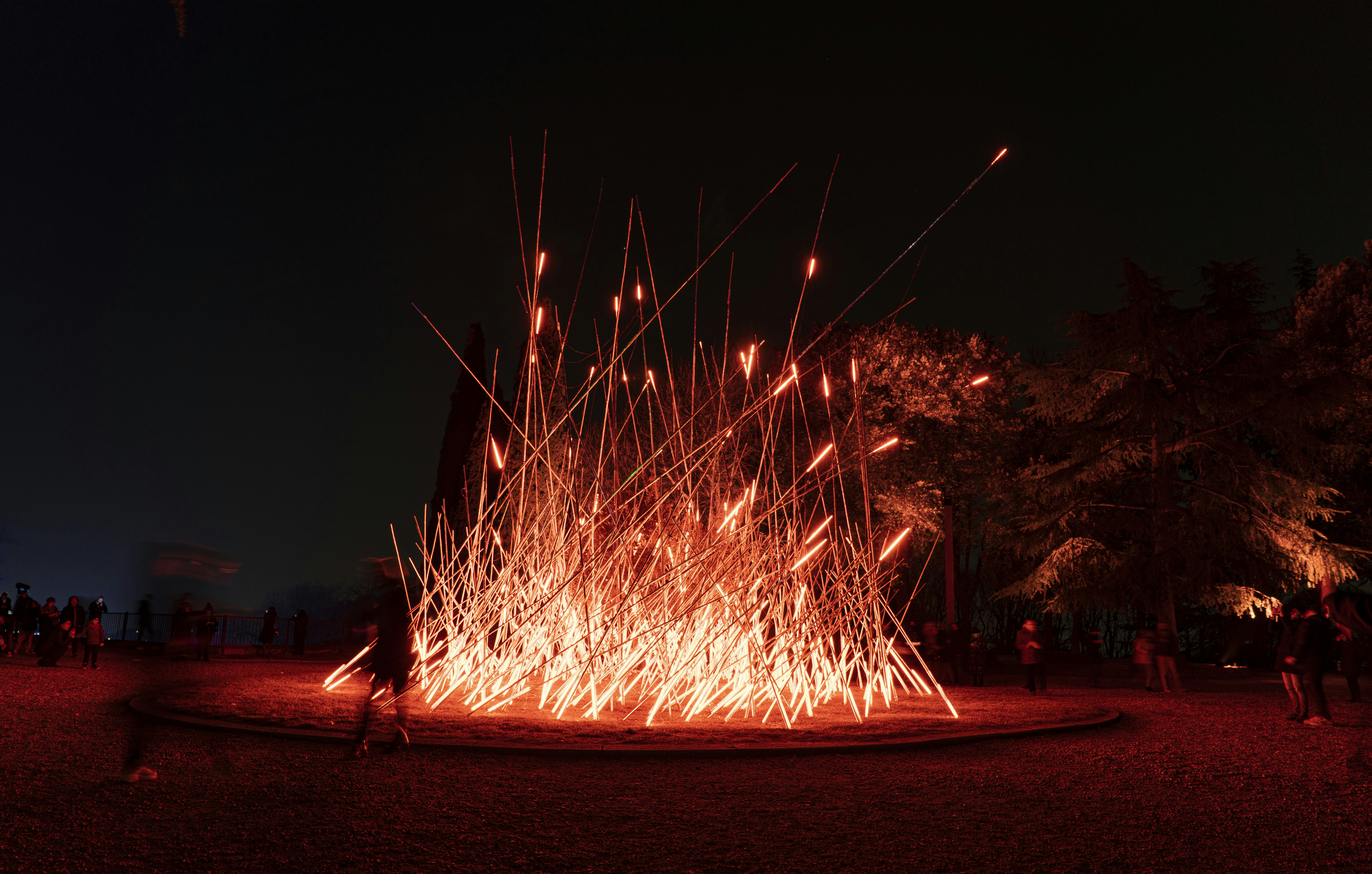 Eine Gruppe von Menschen, die um eine Feuerstelle stehen