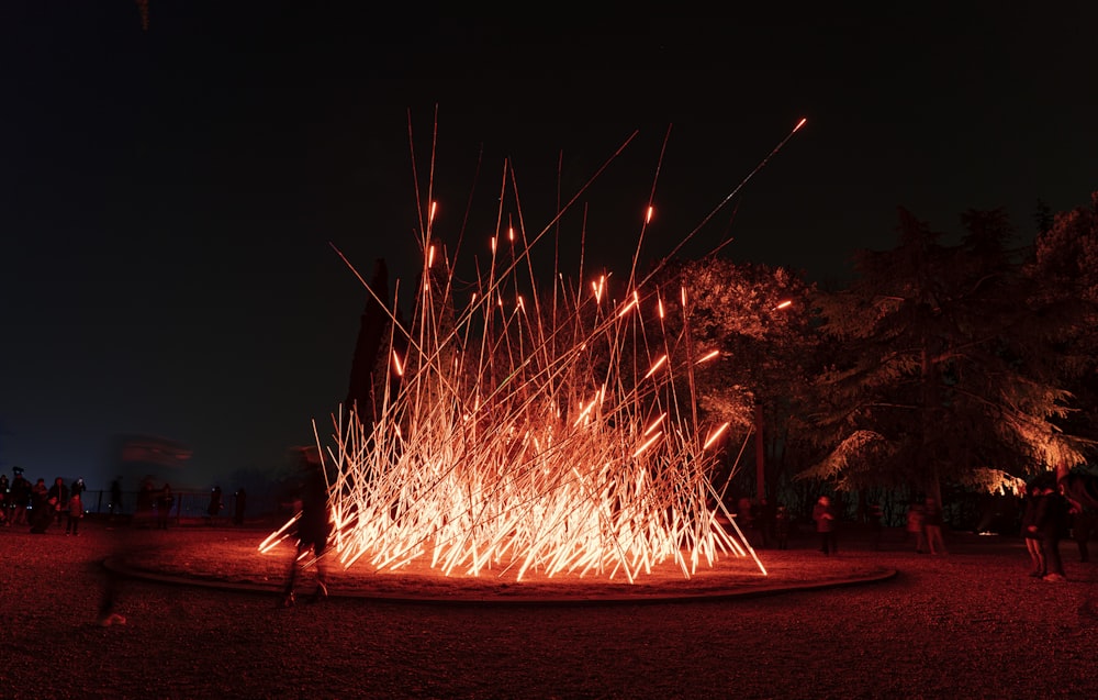 a group of people standing around a fire pit