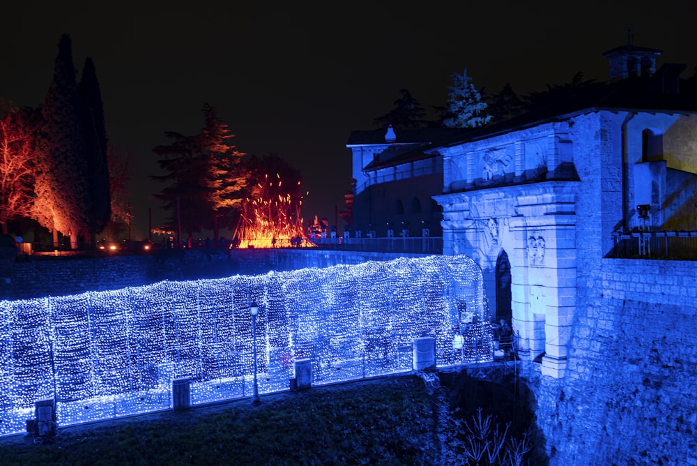 a wall covered in blue lights next to a building