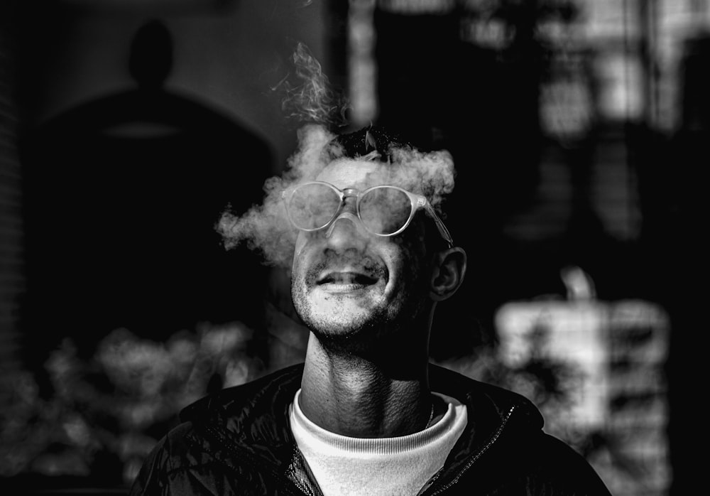 Un uomo che fuma una sigaretta in una foto in bianco e nero