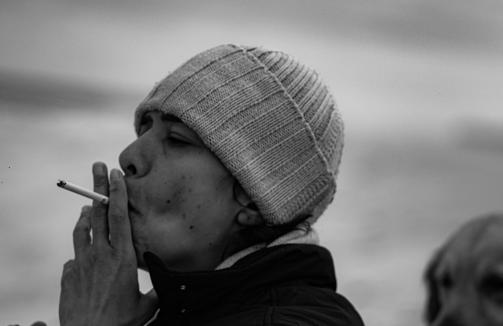 Un uomo che fuma una sigaretta in una foto in bianco e nero