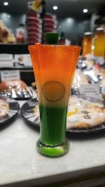 A vibrant glass of chilled Banarasi thandai garnished with rose petals and nuts.