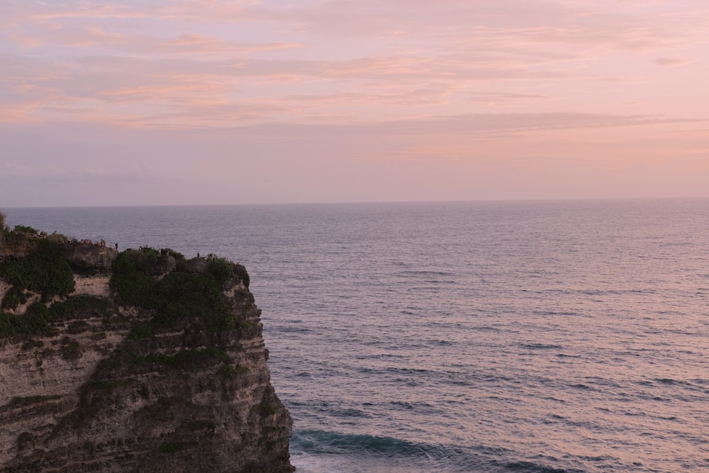 a person standing on the edge of a cliff overlooking the ocean