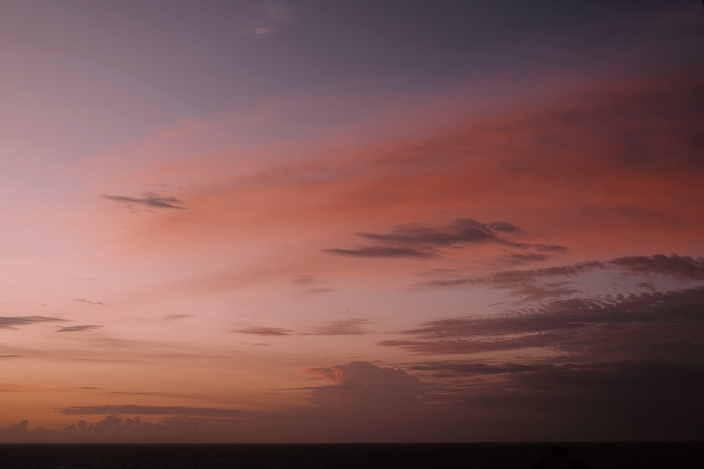 the sky is pink and purple as the sun sets