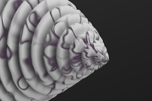 A digitally rendered abstract form resembling a cone or spiral with multiple layers that create a stepped pattern. The surface is smooth and features subtle shading with a monochromatic color scheme, primarily consisting of shades of gray. The structure appears to be floating against a dark gray background, emphasizing its intricate and geometric design.